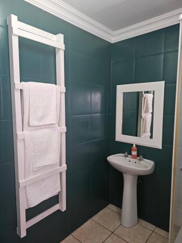 y baño con lavabo, espejo y toallas. en Amberdale Estate Self Catering, en Queenstown