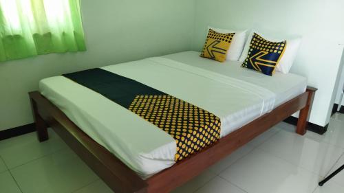 a bed with a wooden frame with pillows on it at Homestay Almadina Syariah in Jepara