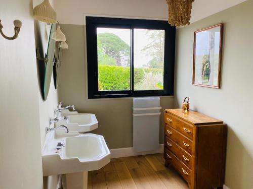 une salle de bain avec deux lavabos et une fenêtre dans l'établissement La Zing-Ara, à Busque