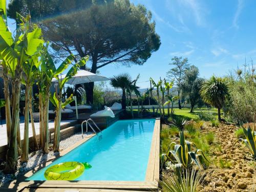 une piscine dans un jardin arboré dans l'établissement La Zing-Ara, à Busque