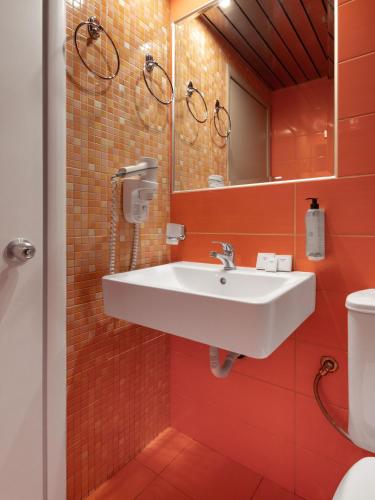 a bathroom with a sink and a mirror at Hotel Nafpaktos in Nafpaktos