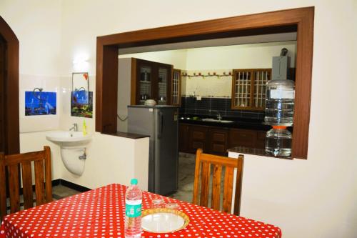 a kitchen with a table with a red and white polka dot table cloth at Golden Gate Serviced Apartment in Chennai