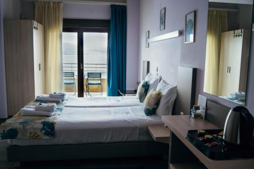a bedroom with a large bed with a balcony at Drenia Studios in Ammouliani