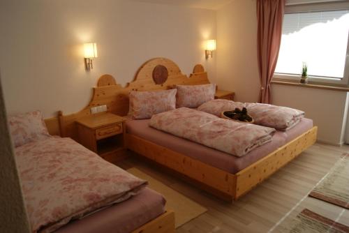 a bedroom with two beds with a cat sitting on them at Haus Elena in Längenfeld