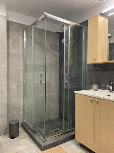 a shower with a glass door in a bathroom at Athenian Modern 2BD Apt next to Metro Panepistimio in Athens