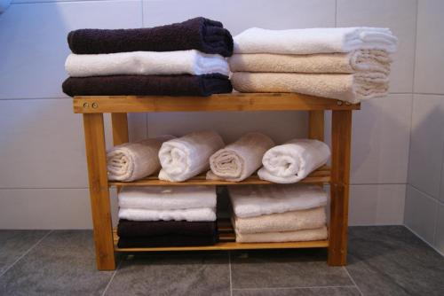 レンゲンフェルトにあるHaus Elenaのバスルームの棚にタオルを積み重ねる