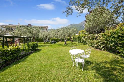 een tafel en stoelen in een grasveld bij Margherita near lake-child friendly - Happy Rentals in Toscolano Maderno
