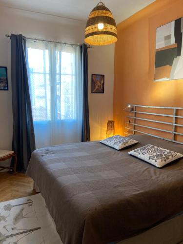 a bedroom with a bed and a large window at Bel appartement de 40m² à louer in Nice