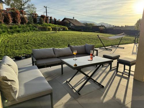 un patio con sofá, mesa y sillas en Villa spacieuse Vue montagne, en Cranves-Sales