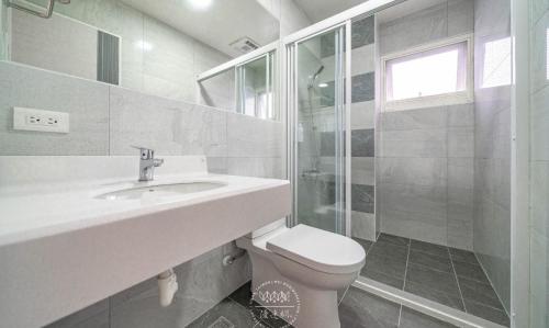 ein weißes Bad mit einem Waschbecken und einem WC in der Unterkunft Jingchao B&B in Zhuangwei
