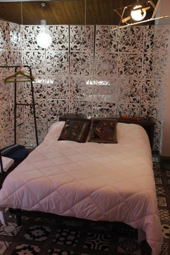 ein Schlafzimmer mit einem weißen Bett mit gemusterter Wand in der Unterkunft El Akito, Huéscar in Huéscar