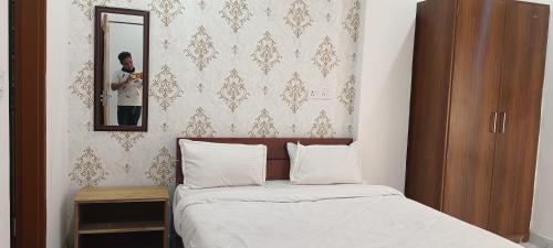 Ein Mann fotografiert ein Bett in einem Schlafzimmer. in der Unterkunft Radhika Hotel in Jaipur