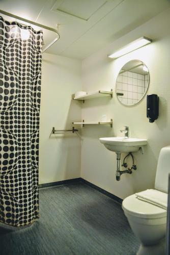 a bathroom with a toilet and a sink and a mirror at Støberiet in Svendborg