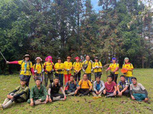 a group of people in yellow shirts posing for a picture at Wind's House Ha Giang in Ha Giang