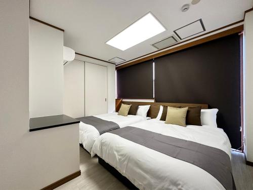 a bedroom with two beds and a skylight at Luxes - 2Br Apt for 10ppl Very Good Location in Hijiyamachō