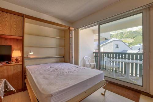 une chambre avec un lit et un balcon dans l'établissement Appartement Val Soleil à 250 m des pistes, à Gourette