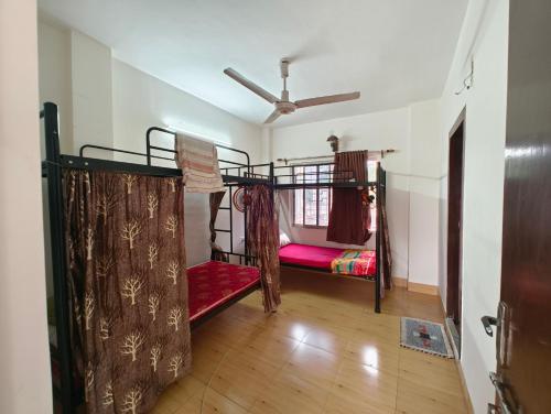 a room with two bunk beds and a ceiling at Calcutta Backpackers in Kolkata