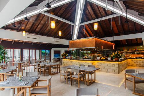a restaurant with tables and chairs and a kitchen at Grand Hyatt Jakarta in Jakarta