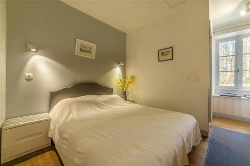 une chambre avec un lit blanc et une fenêtre dans l'établissement Gîtes Le Carpe Diem, Cottage Le Petit Pattaris, à Frayssinet-le-Gélat