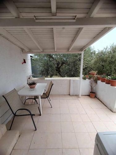 a patio with a table and chairs on a patio at Lake House in Yiannoulaíika