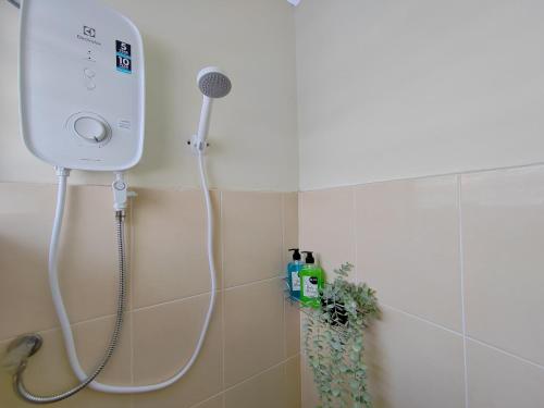 uma casa de banho com uma cabeça de chuveiro em Sunway Tambun Salesman Stay 5 Bedroom 10pax by IWH em Ipoh