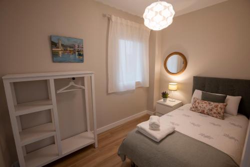 - une petite chambre avec un lit et un miroir dans l'établissement La Marina Beach 3 bedrooms Sun & Golf, à Torre de Benagalbón