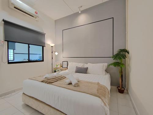 a white bedroom with a large bed with a large screen at Sunway Tambun Salesman Stay 5 Bedroom 10pax by IWH in Ipoh