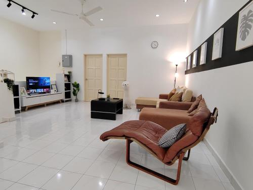 a living room with a couch and a tv at Sunway Tambun Salesman Stay 5 Bedroom 10pax by IWH in Ipoh