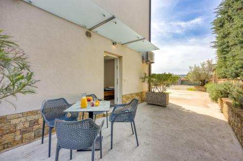 einen Tisch und Stühle auf der Terrasse eines Hauses in der Unterkunft Coastal Countryside Oasis Apartment Deni - Happy Rentals in Koper