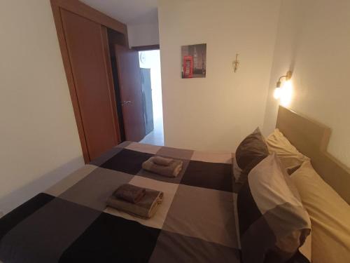 a bed in a room with two towels on it at Apartamento London Complex Amaya Fuerteventura in Costa de Antigua