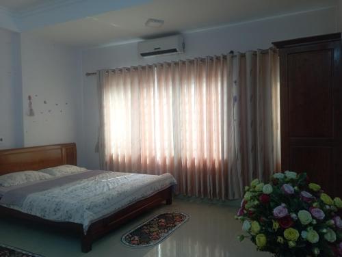 a bedroom with a bed and a large window at LyLy Homestay in Dien Bien Phu