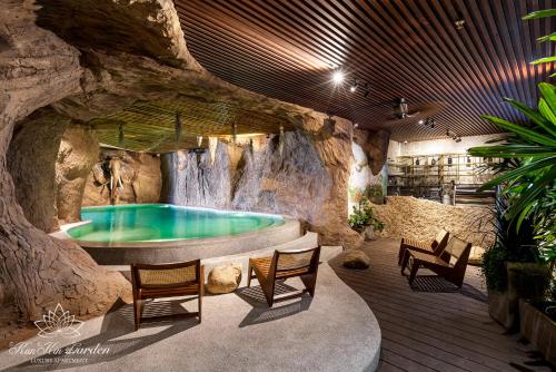 a hot tub in a rock wall with a waterfall at KunKin Garden Aparthotel in Ho Chi Minh City