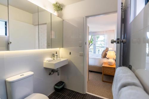 a bathroom with a toilet and a sink and a mirror at Riverside Studio apartment in Brisbane