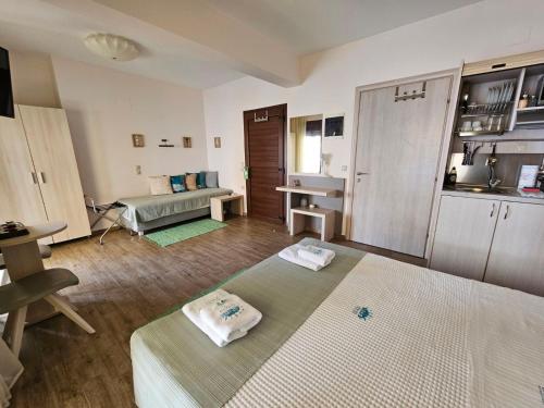 a living room with two beds and a kitchen at Drenia Studios in Ammouliani