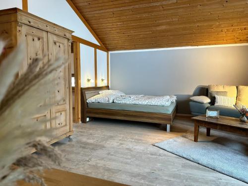 a living room with a bed and a couch at Appartement Hochwildfeuerberg in Steingaden