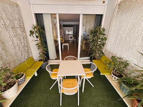 Unique Sea & City Lifestyle Studio في ليماسول: طاولة وكراسي في غرفة بها نباتات