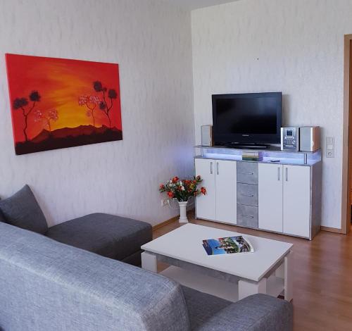 a living room with a couch and a flat screen tv at Ferienwohnung Kurparkblick in Bad Rodach