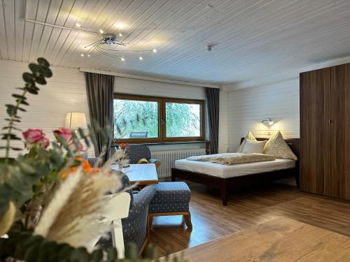 a hotel room with a bed and a table and chairs at Appartement Tegelberg in Steingaden