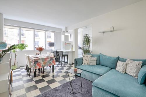 un salon avec un canapé bleu et une table dans l'établissement Le Coin des Lecteurs - 1er arrondissement 75m², à Paris