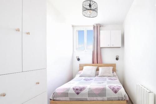 une petite chambre avec un lit et une fenêtre dans l'établissement En bord de mer - Appt à moins d'un km de la plage, à Barneville-Carteret