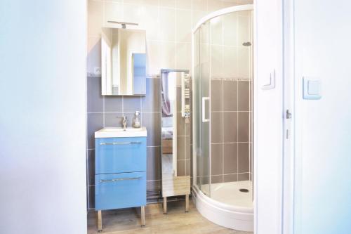 une salle de bain avec un lavabo bleu et une douche dans l'établissement En bord de mer - Appt à moins d'un km de la plage, à Barneville-Carteret