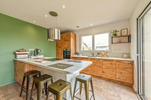 une cuisine avec des murs verts et un grand îlot avec des tabourets dans l'établissement Le 101 - Plage du Dossen à Santec à 1.5 km, à Santec