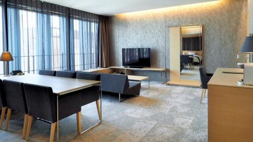a room with a table and chairs and a television at Hotel Royal Classic Osaka in Osaka