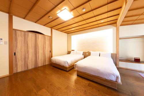 a bedroom with two beds and a large window at Kawakamiya Kasuitei in Gero