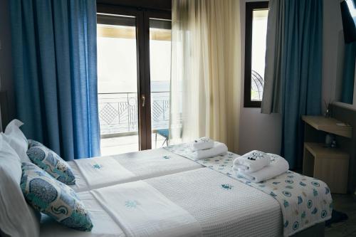 a bedroom with a bed with towels on it at Drenia Studios in Ammouliani