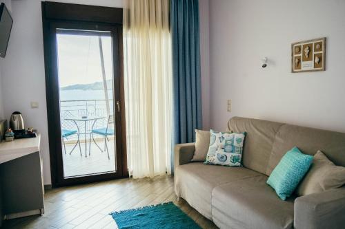 a living room with a couch and a balcony at Drenia Studios in Ammouliani