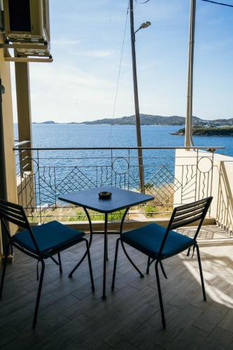 a table and chairs on a balcony with a view of the water at Drenia Studios in Ammouliani