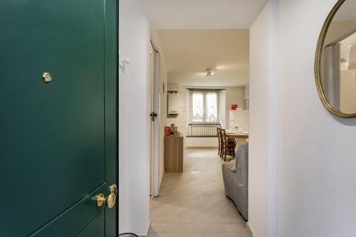 einen Flur mit grüner Tür und ein Wohnzimmer in der Unterkunft Comfy Apartment Near the Harbor by Wonderful Italy in Genua