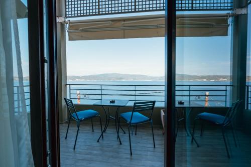 a table and chairs on a balcony with a view of the water at Drenia Studios in Ammouliani