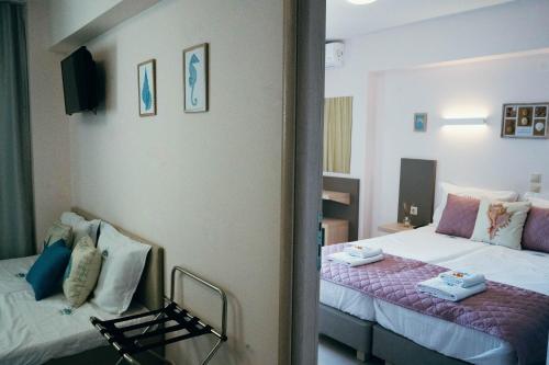 a hotel room with two beds and a tv at Drenia Studios in Ammouliani